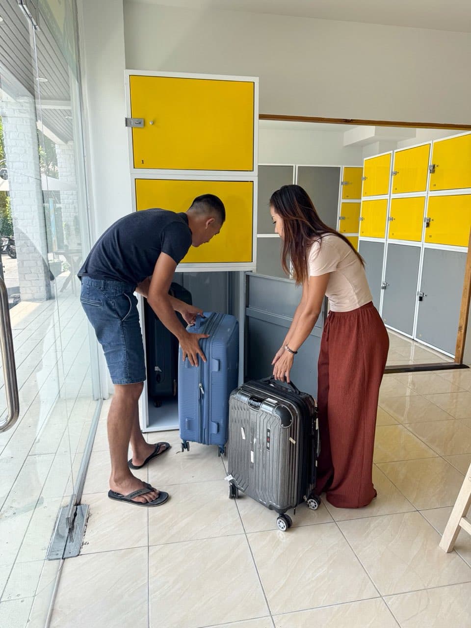 Our staff helping a customer load a suitcase into a locker